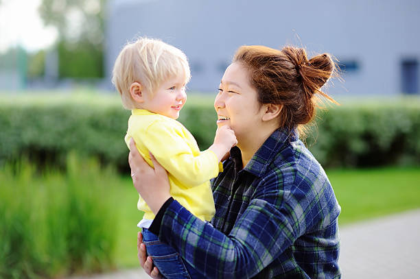 Young asian woman with cute caucasian toddler boy Young asian woman with cute caucasian toddler boy. Babysitting concept asian nanny stock pictures, royalty-free photos & images