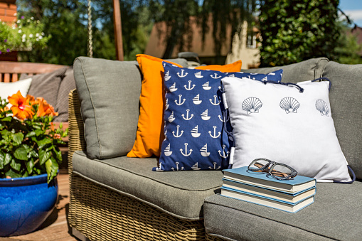 Image of pattern pillows lying on a rattan outdoor sofa