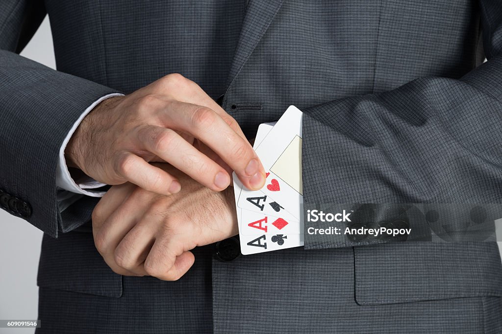 Businessman Removing Ace Cards From Sleeve Midsection of businessman removing ace cards from sleeve in office Ace Stock Photo