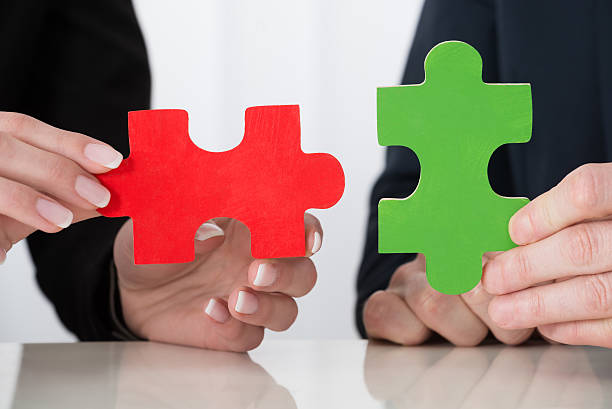 istock Businessperson Hand Holding Puzzle Pieces 609092870