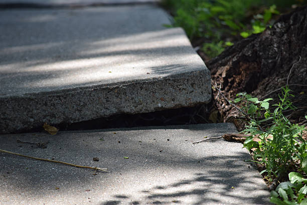 cracked and broken sidewalk in need of repair - uneven imagens e fotografias de stock