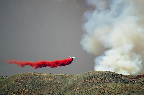 istock White Aircraft Dropping Fire Retardant While Battling Raging Wildfire 609096888