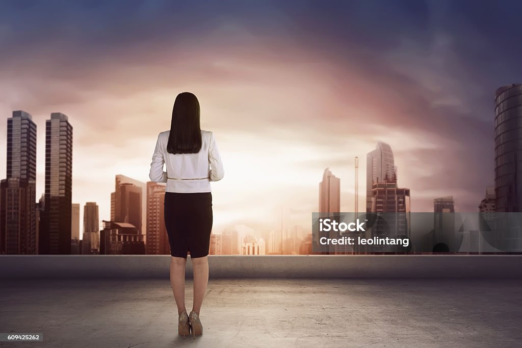 Femme d’affaires asiatique sur le toit et regardant le - Photo de Vue de dos libre de droits