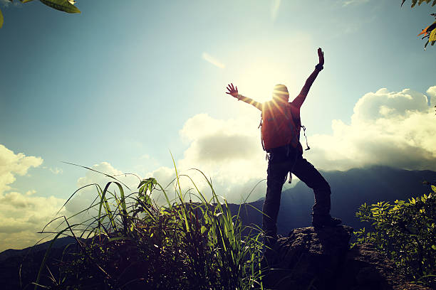istock successful young woman backpacker open arms on mountain peak 609425502