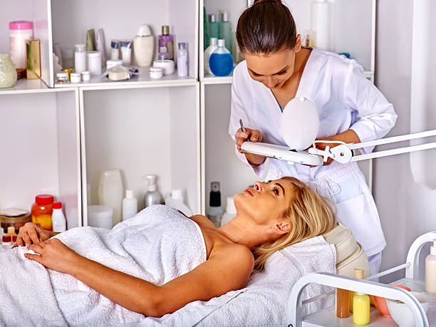 Woman middle-aged lying in spa salon. Tweezing eyebrow beautician. Woman middle-aged in spa salon with young beautician. Tweezing eyebrow by beautician in spa salon. aesthetician photos stock pictures, royalty-free photos & images