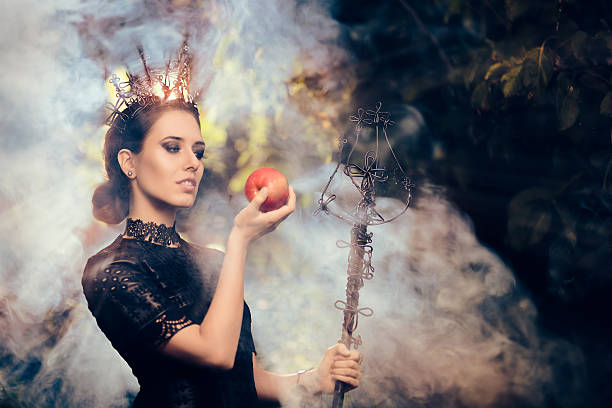 istock Evil Queen with Poisoned  Apple in Misty Forest 609431644