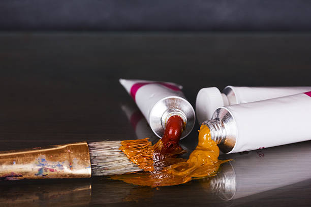 istock Open tubes of brown paint and brushes 609439810