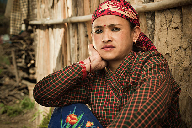 Serene, traditional Asian peasant woman looking at camera and thinking.