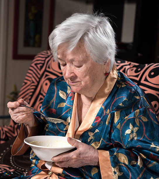istock Old woman looking at torn 100 hundred dollar bill 609442970
