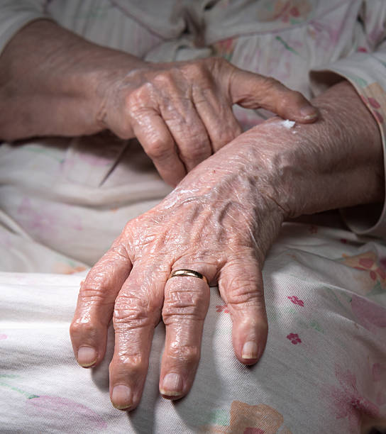 istock Old woman applying hand cream 609442998