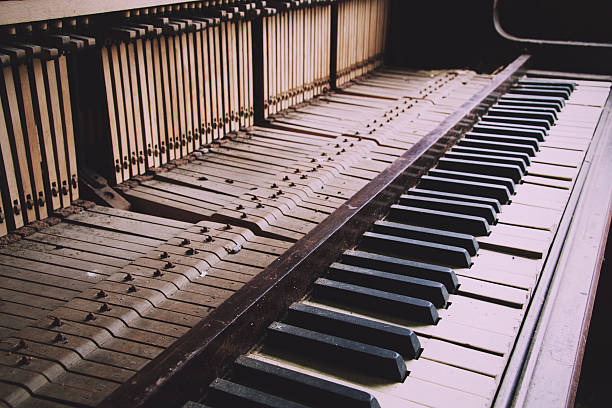 istock Old broken disused piano with damaged keys Vintage Retro Filter. 609444590