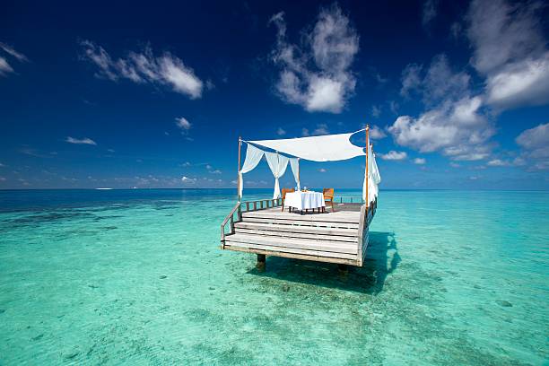 istock Oasis restaurant table among the sea with blue sky 609520716