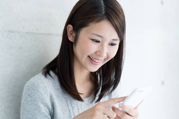 istock Asian young woman using smart phone 609528384