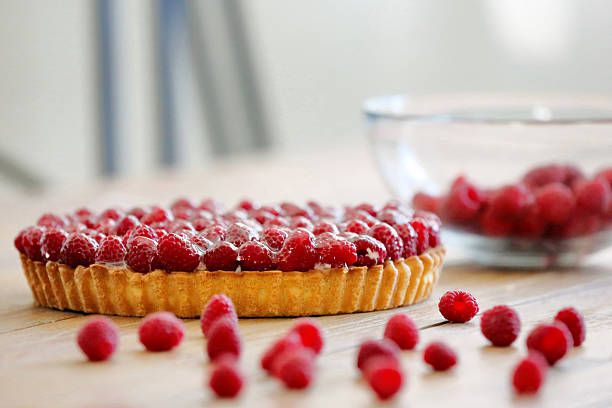 Tart with fresh raspberries on wooden background