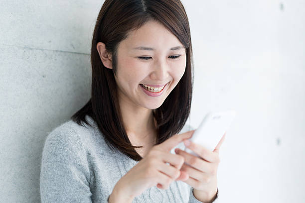 istock Asian young woman using smart phone 609531264