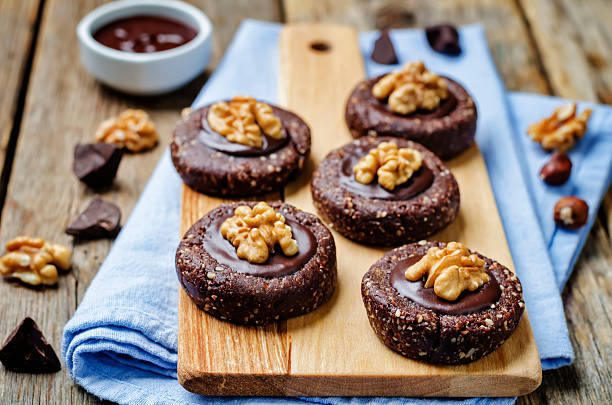 istock Raw vegan chocolate dates hazelnut cookies with chocolate frosting and walnuts 609534588
