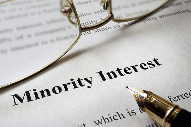 istock Sign minority interest on a paper and glasses. 609624970