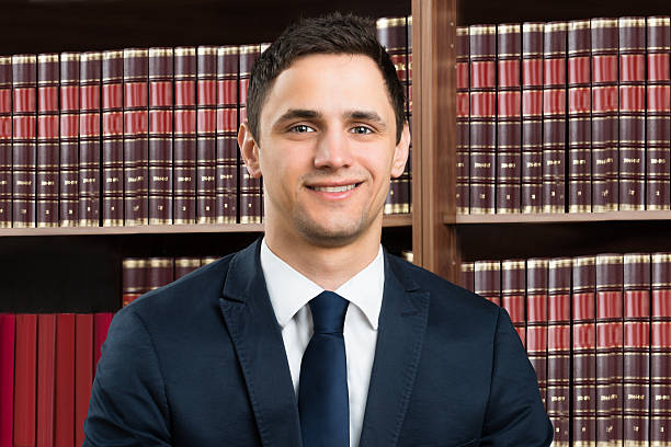 istock Confident Lawyer Standing Arms Crossed Against Bookshelf 609625412