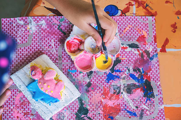 istock kid painting on the plaster statue. 609686518