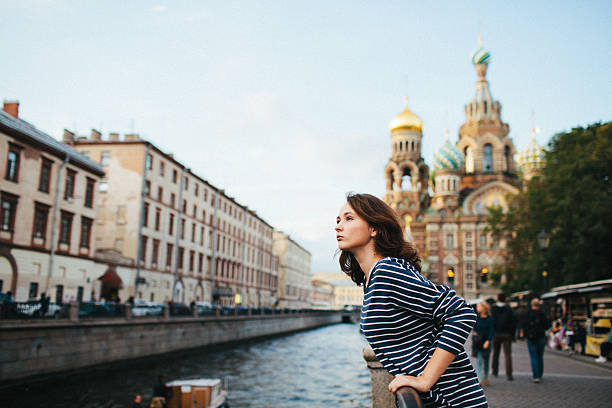 Young  Caucasian girl standing on the river embankment in St. Petersburg, Russia