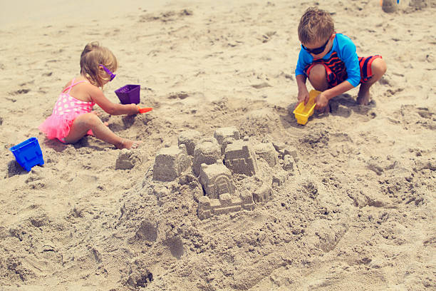 istock kids building sand castle on summer beach 609687518