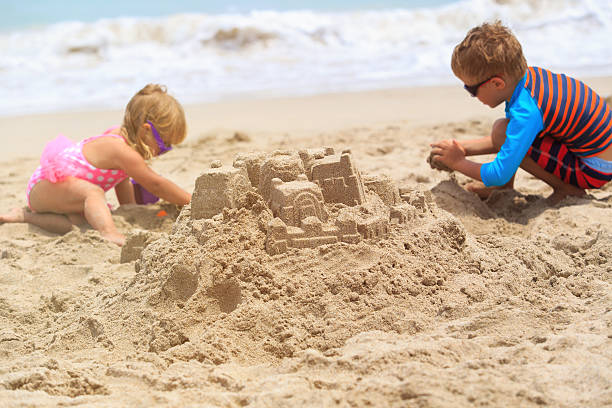 istock kids building sand castle on summer beach 609687678