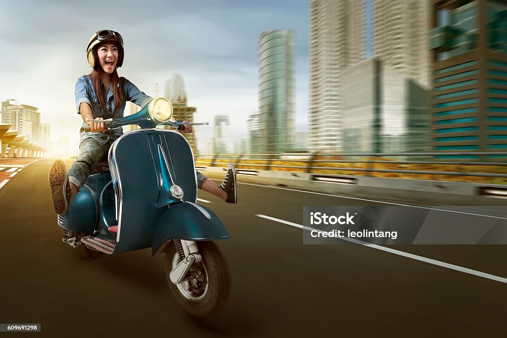 Asian woman riding scooter and wearing helmet Asian woman riding scooter and wearing helmet on the street Motorcycle Stock Photo