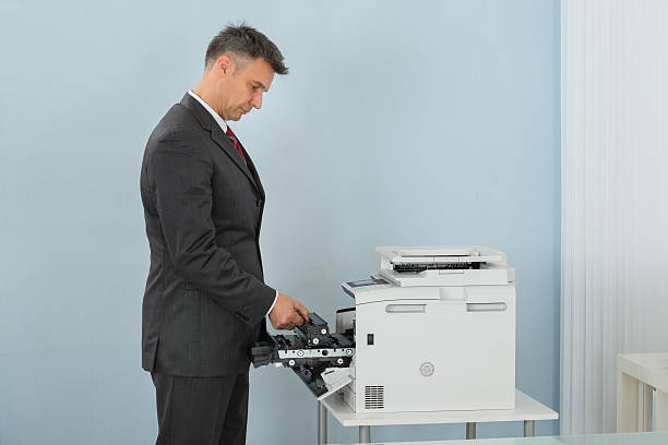 istock Businessman Fixing Cartridge In Printer Machine At Office 609693708