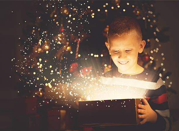 istock Cute boy opening a magical present on Christmas eve 609694176