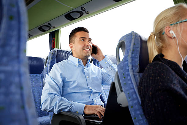 hombre feliz con teléfono inteligente y portátil en autobús de viaje - bus coach bus travel red fotografías e imágenes de stock