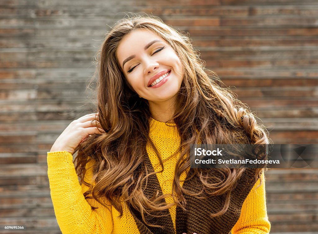Beautiful brunette woman  over wooden background. Beautiful smiling brunette woman with luxurious hair over wooden background. Autumn time. Fall season. Autumn Stock Photo