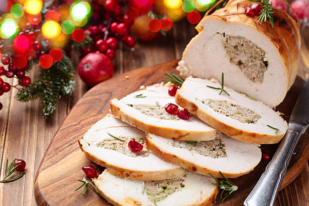 Turkey  breast for holidays. Stuffed turkey breast with pomegranate and rosemary  on cutting board. turkey breast stock pictures, royalty-free photos & images