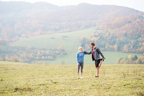 istock Two young beautiful runners in autumn nature, stretching legs 609696308
