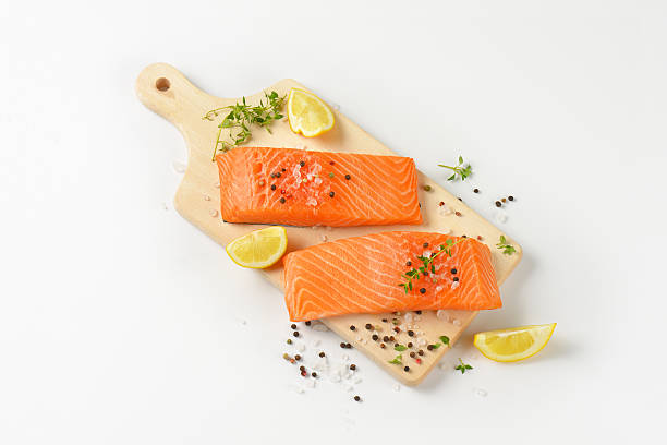 raw salmon fillets on cutting board stock photo