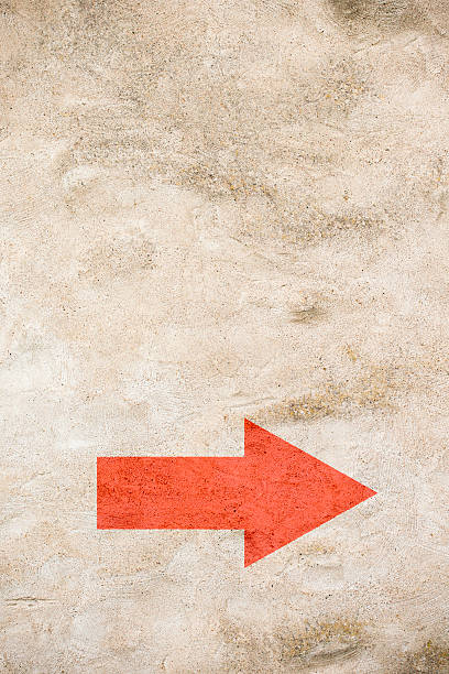 istock Arrow on grungy wall pointing down 609697040