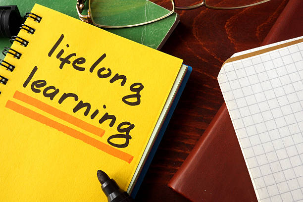 Notebook with lifelong learning  sign on a table. Notebook with  lifelong learning sign on a table. Education concept. nontraditional student photos stock pictures, royalty-free photos & images