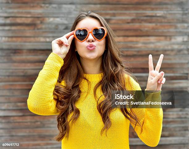 Beautiful Brunette Woman In Sunglasses Blowing Lips Kiss Wooden Background Stock Photo - Download Image Now