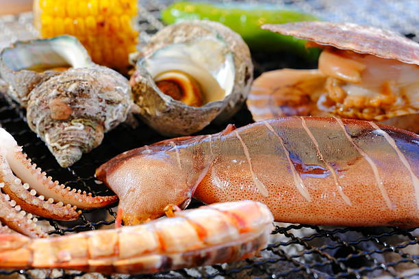 istock Grilling abalone, squid, shrimp, clams and corn with hot charcoa 609705504