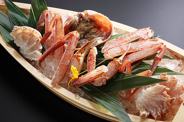 istock Red Echizen king crab legs with ice on wooden boat 609705622