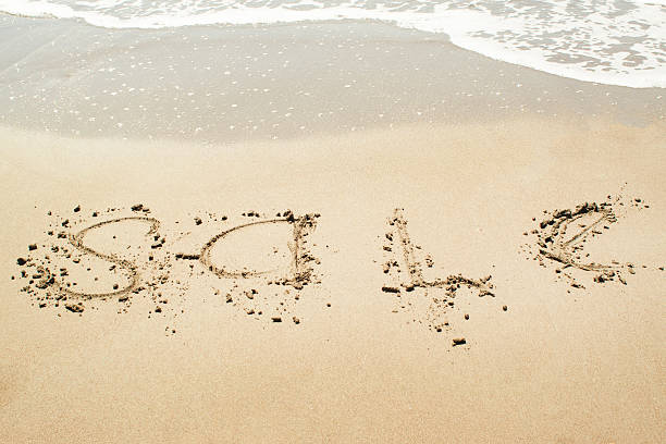 istock Sale sign on the beach 609707040