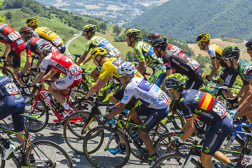 Col D'aspin, France - July 15, 2015: Froome of Team sky, in Yellow Jersey and his main rival Quintana of Movistar Team, in White Jersey, climbing,inside the peloton, the road to Col D'Aspin  in Pyrenees Mountains during the stage 11 of Le Tour de France 2015.
