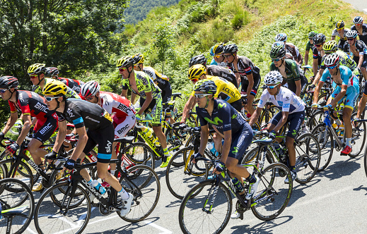 Col D'aspin, France - July 15, 2015: Froome of Team sky, in Yellow Jersey and his main rivals Quintana of Movistar Team, in White Jersey and Nibali of Astana Team, climbing,inside the peloton, the road to Col D'Aspin  in Pyrenees Mountains during the stage 11 of Le Tour de France 2015.
