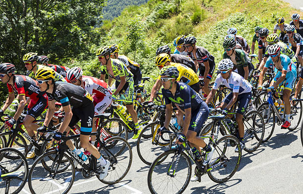 The Fight Inside the Peloton - Tour de France 2015 Col D'aspin, France - July 15, 2015: Froome of Team sky, in Yellow Jersey and his main rivals Quintana of Movistar Team, in White Jersey and Nibali of Astana Team, climbing,inside the peloton, the road to Col D'Aspin  in Pyrenees Mountains during the stage 11 of Le Tour de France 2015. cycling vest photos stock pictures, royalty-free photos & images