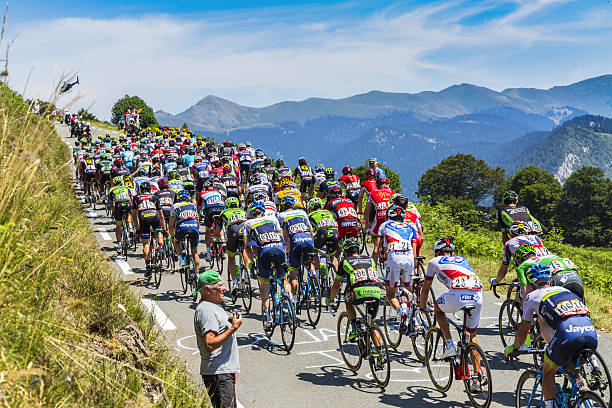 The Peloton on Col d'Aspin - Tour de France 2015 Col D'aspin, France - July 15, 2015: The peloton climbing the road to Col D'Aspin  in Pyrenees Mountains during the stage 11 of Le Tour de France 2015. cycle racing stock pictures, royalty-free photos & images