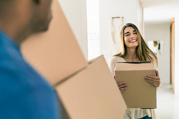 istock Happy woman with cardboard box looking at man 609709962