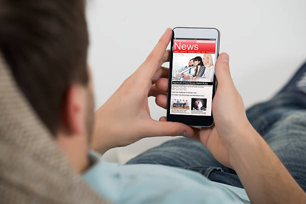 istock Man Reading Online News On Mobile Phone 609710374
