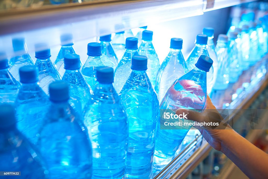 Agua embotellada en estantería en supermercado - Foto de stock de Botella de agua libre de derechos