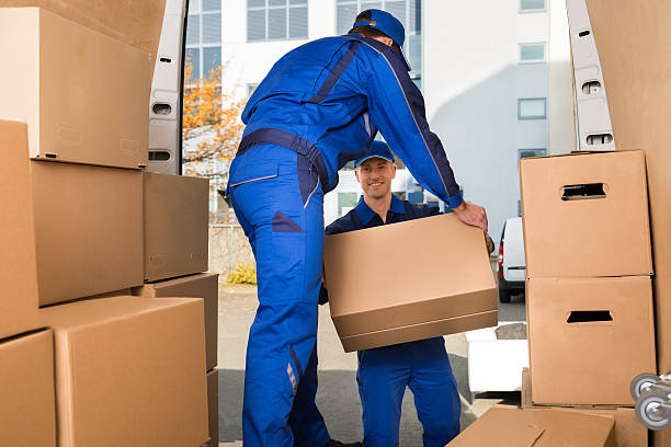 Movers Carrying Sofa Outside Truck On Street stock photo