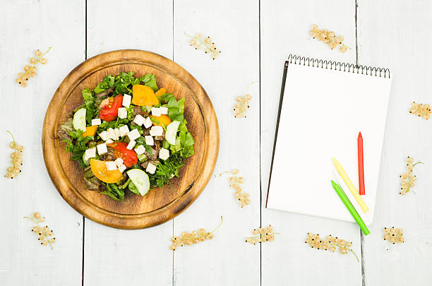 istock salad of fresh vegetables and a blank notebook 609712432