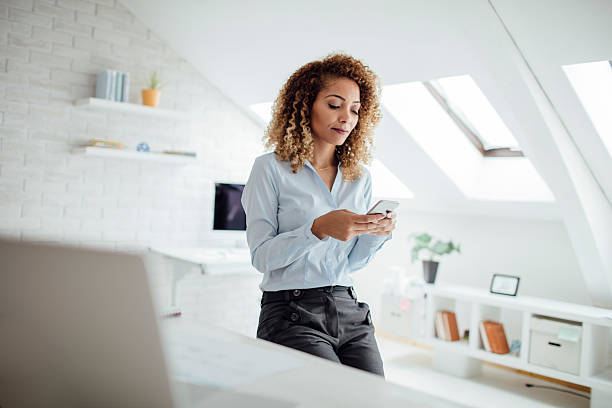 istock Latina Businesswoman Texting In Her Office 609716666